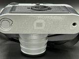 a silver camera with a black strap on a table