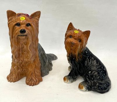 deux figurines de chiens assis l'une à côté de l'autre