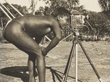 une vieille photo en noir et blanc représentant un homme avec un appareil photo posé sur un trépied