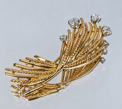 an image of a gold and diamond broochle on a white surface