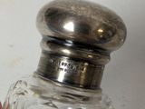 a person holding a small glass bottle with a silver top