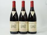 three bottles of red wine sitting on top of a white table