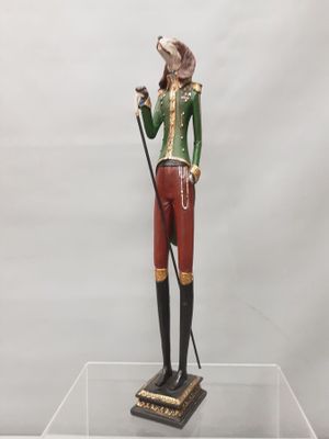 figurine of a man in a green jacket and red pants holding a cane