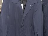 two jackets hanging on a rack in a room