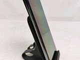 a close up of a cell phone on a stand on a white surface