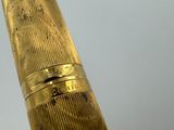 a close up of a gold pen with a ring on it