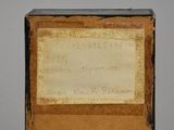 an old box with a label on it sitting on top of a table