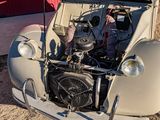 an old car with the hood up and the engine in the back