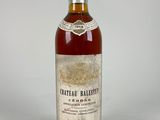 an old bottle of wine sitting on top of a white table