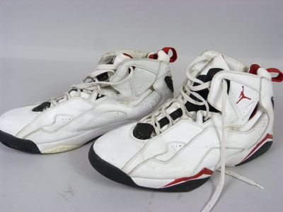 une paire de baskets blanches et noires avec des touches de rouge sur fond blanc
