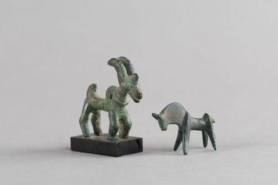 deux figurines représentant une chèvre et une chèvre, posées sur un socle