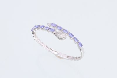 un gros plan d'une bague ornée de pierres bleues et blanches