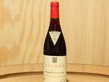 a bottle of wine sitting on top of a wooden barrel