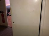 a white refrigerator sitting in a kitchen next to a door