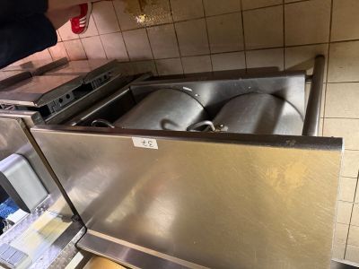 a stainless steel sink with two kegs inside of it