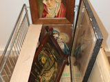 a pile of framed pictures on the floor next to a wall
