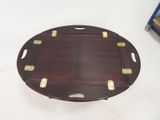 a wooden tray that has gold studded handles on it