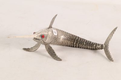 a silver fish with red eyes on a white surface