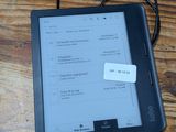 un Kindle posé sur la table, avec un mot accroché dessus