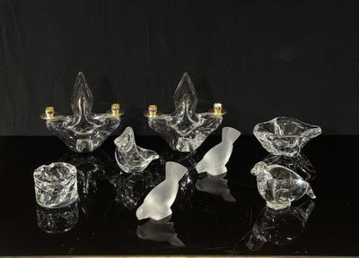 six bougeoirs en verre transparent posés sur une table noire, sur fond noir