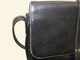 a black purse that is sitting on top of a table