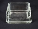 a glass ashtray on a black background with a black background