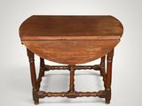 an antique oak drop leaf table with turned legs