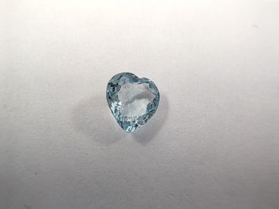 a heart shaped aquamarine blue topaz gems on a white surface