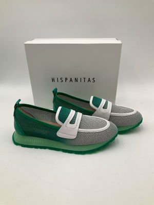 une paire de chaussures vertes et blanches avec une boîte en arrière-plan