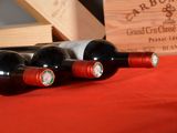 three bottles of red wine sitting next to a wooden box