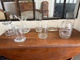 cinq verres posés sur une table, avec un miroir en arrière-plan