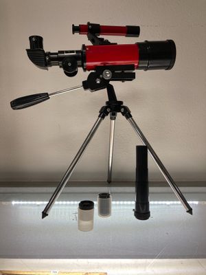une image représentant un télescope posé sur un trépied à côté d'un appareil photo