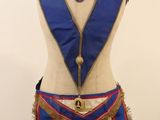 an image of a mannequin wearing a blue and red apron with a clock on it