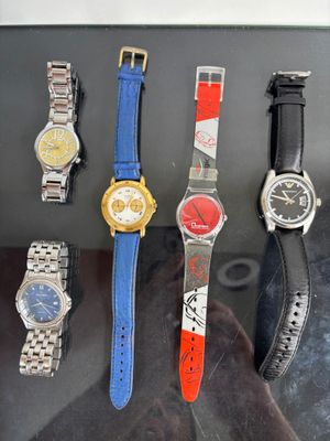 five different watches on display in a glass case