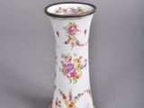 a white vase with a floral design on it