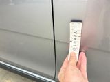 a hand that is holding a piece of paper near a car door