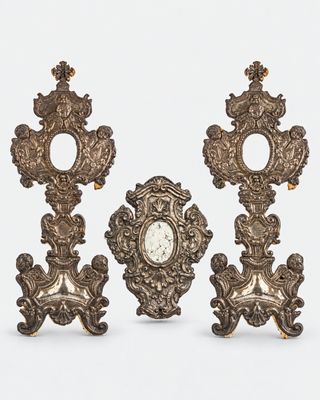 trois horloges anciennes sont posées les unes sur les autres sur une surface blanche