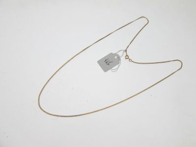 une photo d'un collier muni d'une étiquette, posé sur une surface blanche
