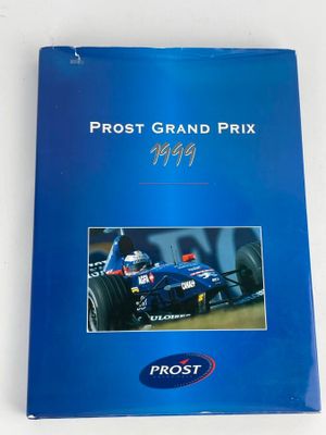 un gros plan sur un livre bleu avec la photo d'une voiture de course