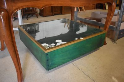 a wooden table with a glass top and a drawer underneath it