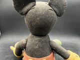 mickey mouse plush toy sitting on top of a black surface