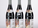 trois bouteilles de vin décorées de paillettes, alignées les unes à côté des autres