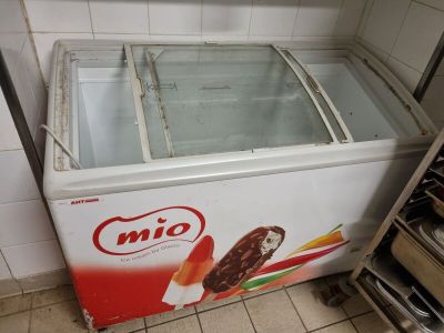 a refrigerator with ice cream inside of it in a kitchen