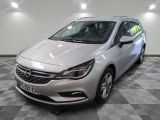 L'Opel argentée est garée dans une grande pièce au sol carrelé en damier.