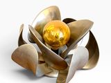 une fleur en métal renfermant une boule dorée