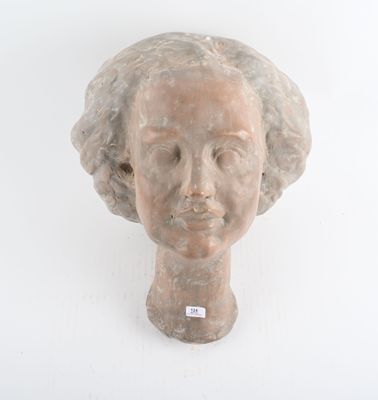 une sculpture représentant une tête de femme sur un mur blanc