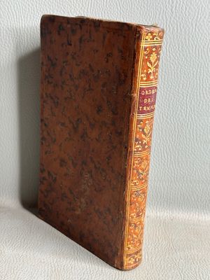 un vieux livre posé sur une table blanche près d'un mur