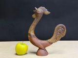 a bird statue next to an apple on a table