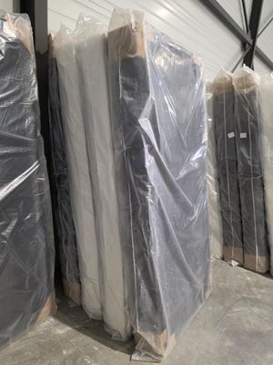 de nombreux matelas emballés dans du plastique dans un entrepôt