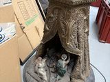 une statue représentant un homme et une femme assis dans une crèche